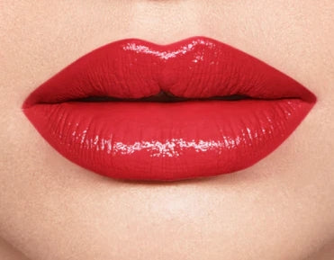 Close-up of red lips with a glossy finish on a beige background