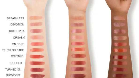 Three hands with various shades of lipstick swatches on a white background