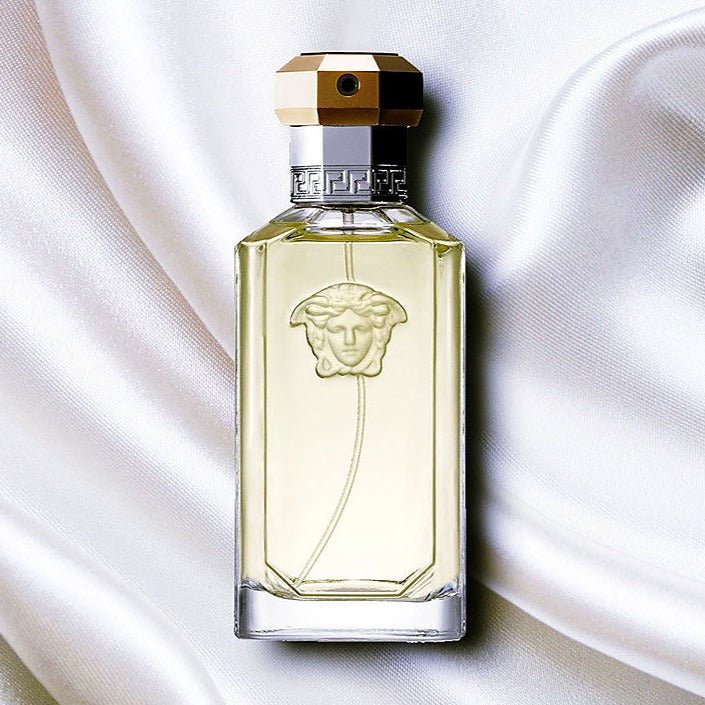 Perfume bottle with gold cap on a white fabric background