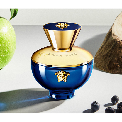 Blue and gold perfume bottle with decorative elements on a light background